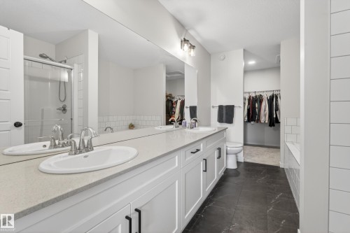 Double vanity with white cabinetry, light stone-finish countertop, and undermount sinks - 22836 94 Avenue, Edmonton, AB 