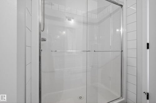 Shower enclosure featuring clear glass sliding doors and chrome hardware - 22836 94 Avenue, Edmonton, AB 