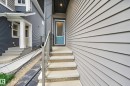 Front entryway featuring a teal door, concrete steps with exposed aggregate treads, and a metal handrail - 22836 94 Avenue, Edmonton, AB 