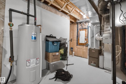 Utility area featuring a water heater, furnace, and exposed ceiling joists - 22836 94 Avenue, Edmonton, AB 