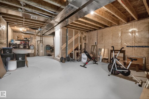 Spacious unfinished basement offering extensive possibilities for customization, featuring exposed ceiling joists, insulated walls, and a painted concrete floor - 22836 94 Avenue, Edmonton, AB 