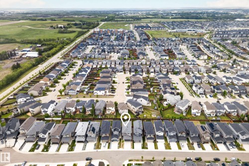 Aerial view of a residential community with a mix of single-family homes and townhomes, featuring paved streets and green spaces - 22836 94 Avenue, Edmonton, AB 