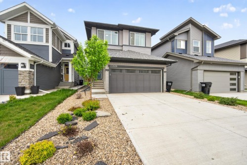 Contemporary exterior featuring mixed siding, a dual-tone facade, and an attached garage with a modern door - 22836 94 Avenue, Edmonton, AB 