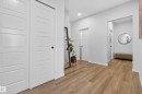 Hallway featuring wood-finish flooring, white paneled doors, recessed lighting, and crisp white baseboards - 22836 94 Avenue, Edmonton, AB 