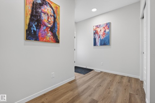 Hallway featuring wood-finish flooring, light grey walls, white trim, and recessed ceiling lighting - 22836 94 Avenue, Edmonton, AB 