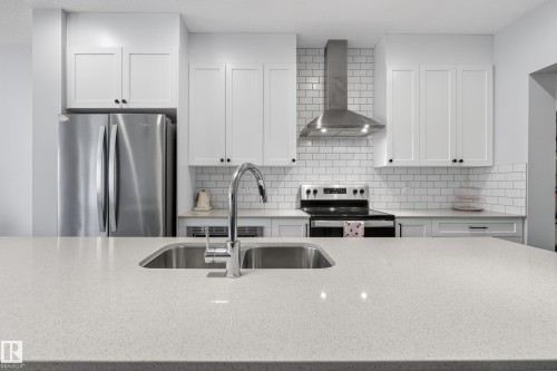 Expansive kitchen island with an undermount double basin sink and gooseneck faucet - 22836 94 Avenue, Edmonton, AB 