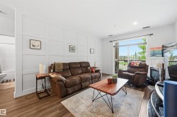 Living area featuring panel accent wall, wood-finish flooring, recessed lighting, and sliding glass door access to an outdoor space - 