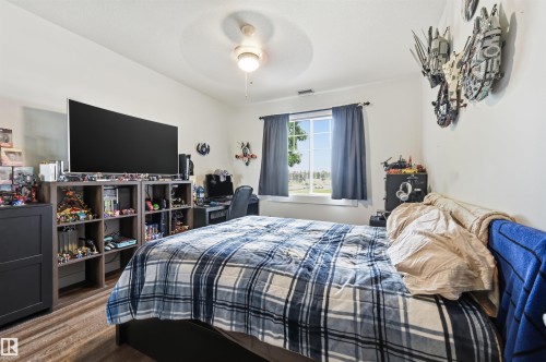 Spacious room with a ceiling fan, a window, wood-finish flooring, and white walls - 217 2503 Hanna Crescent, Edmonton, AB 