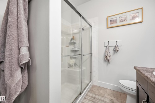 Enclosed shower with clear glass sliding doors and white tile surround - 217 2503 Hanna Crescent, Edmonton, AB 