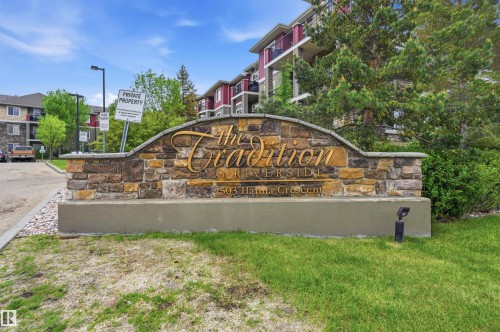 Stone-clad monument sign with "The Tradition Riverside" script lettering - 217 2503 Hanna Crescent, Edmonton, AB 