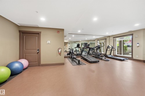 Fitness room featuring full-wall mirrors, recessed lighting, and large windows - 217 2503 Hanna Crescent, Edmonton, AB 