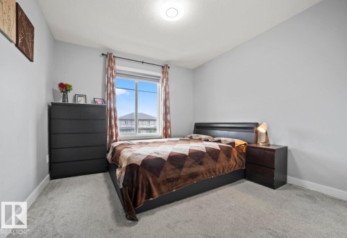 Carpeted room with a large window, a flush-mount ceiling light, and light gray walls - 2153 Maple Road, Edmonton, AB 