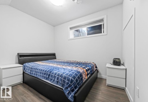 Bedroom featuring wood-finish flooring, white walls, and a recessed window - 2153 Maple Road, Edmonton, AB 
