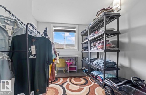 Room with a window, wood-finish flooring, and a wall-mounted light fixture - 2153 Maple Road, Edmonton, AB 