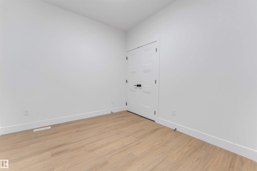 Room featuring light wood-finish flooring, white walls, and bright white trim - 131 24 Street, Edmonton, AB 