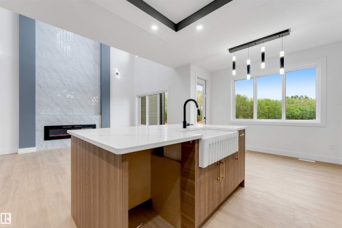 Kitchen island with a farmhouse-style sink and a black gooseneck faucet - 131 24 Street, Edmonton, AB 