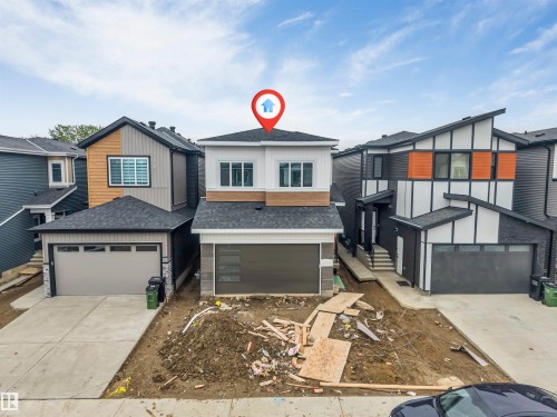 Contemporary two-story residence featuring a dual-tone facade, prominent upper-level windows, and a two-car garage with modern frosted glass inserts - 131 24 Street, Edmonton, AB 