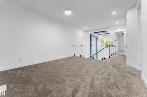 Upper-level space featuring light gray carpeting, white walls, and contemporary recessed lighting - 131 24 Street, Edmonton, AB 