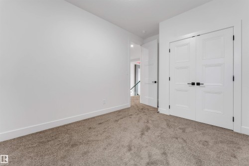 Spacious room featuring plush, neutral-toned carpet and crisp white walls - 131 24 Street, Edmonton, AB 
