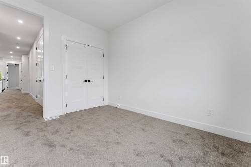 Spacious room featuring neutral carpeting and white walls - 131 24 Street, Edmonton, AB 