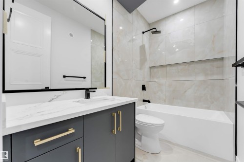 Bathroom featuring a gray vanity with gold-tone hardware, white countertop, and integrated sink - 131 24 Street, Edmonton, AB 