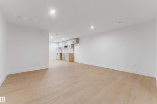 Spacious open-concept area featuring light wood-finish flooring and recessed lighting - 131 24 Street, Edmonton, AB 