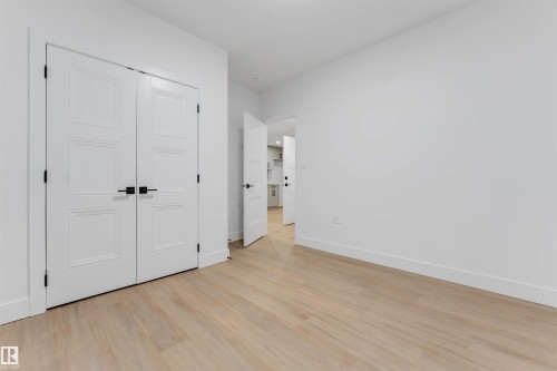 Light wood-finish flooring complements crisp white walls - 131 24 Street, Edmonton, AB 