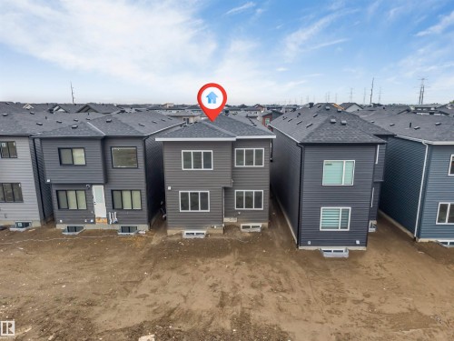 Contemporary gray siding residence featuring multiple large windows, a dark shingle roof, and a rear entrance - 131 24 Street, Edmonton, AB 