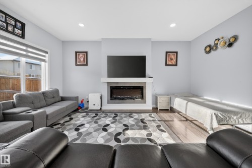 Living area featuring a modern fireplace with a white mantel and a dark hearth - 2084 Graydon Hill, Edmonton, AB 