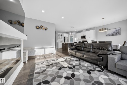 Open-concept living space featuring wood-finish flooring, recessed lighting, and a modern kitchen - 2084 Graydon Hill, Edmonton, AB 
