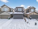 Contemporary two-story residence featuring a dark gray facade with stone accents, a double-car garage, and multiple windows - 2084 Graydon Hill, Edmonton, AB 
