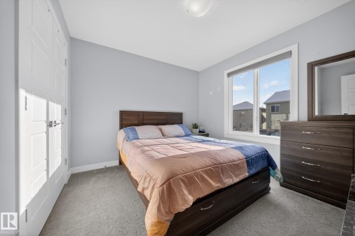 Light blue walls with white trim, gray carpeting, and a window with a roller shade - 2084 Graydon Hill, Edmonton, AB 
