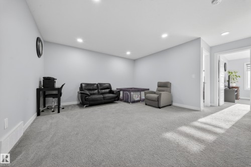 Spacious carpeted room featuring light gray walls, recessed lighting, and white baseboards - 2084 Graydon Hill, Edmonton, AB 