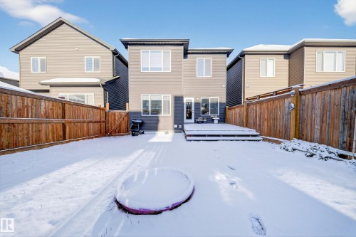 Rear elevation featuring grey horizontal siding, a multi-level wood-finish deck, and a fenced backyard - 2084 Graydon Hill, Edmonton, AB 
