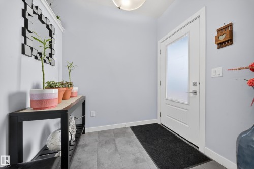 Entryway featuring wood-finish flooring and a contemporary white door with frosted glass panel - 2084 Graydon Hill, Edmonton, AB 