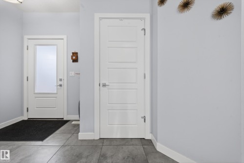 Entryway featuring large format tile flooring and a white paneled door with frosted glass - 2084 Graydon Hill, Edmonton, AB 