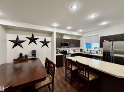 Open-concept kitchen and dining area featuring rich wood-finish flooring - 