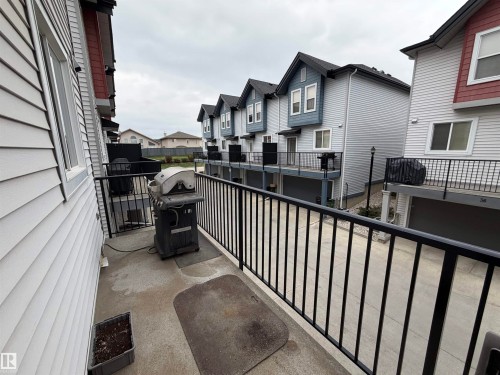Private concrete balcony featuring black metal railings - 45 6075 Schonsee Way, Edmonton, AB 