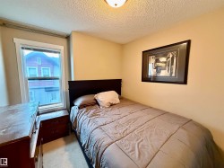 Bedroom featuring neutral wall paint, white trim, a single window, and textured ceiling - 