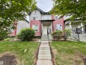 Townhome exterior featuring a two-story façade with horizontal siding and shingle accents - 45 6075 Schonsee Way, Edmonton, AB 