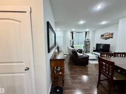 Open-concept living area featuring wood-finish flooring, recessed lighting, and white trim throughout - 