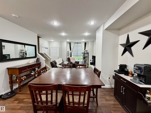 Open-concept living area with dark wood-finish flooring - 45 6075 Schonsee Way, Edmonton, AB 