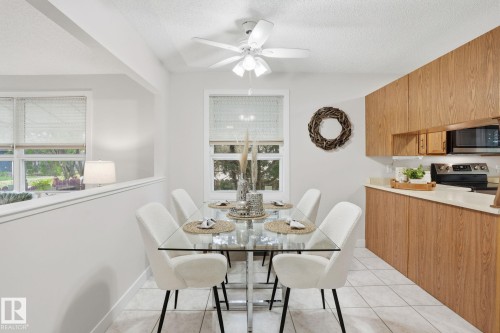 Dining area featuring tile flooring, a glass-top table, and a ceiling fan - 1008 61 Street, Edmonton, AB 