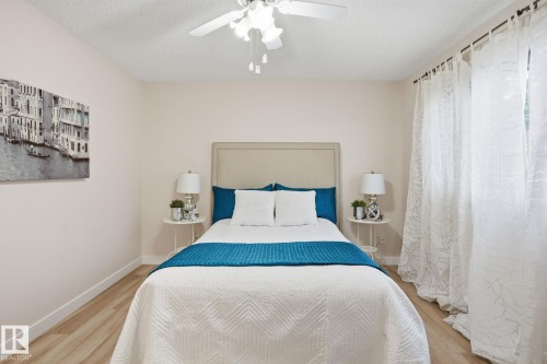 Neutral wall tones, wood-finish flooring, and a ceiling fan with light fixture - 1008 61 Street, Edmonton, AB 