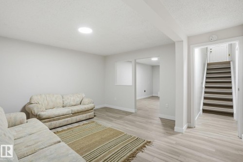 Spacious interior room with light grey walls and light wood-finish flooring - 1008 61 Street, Edmonton, AB 