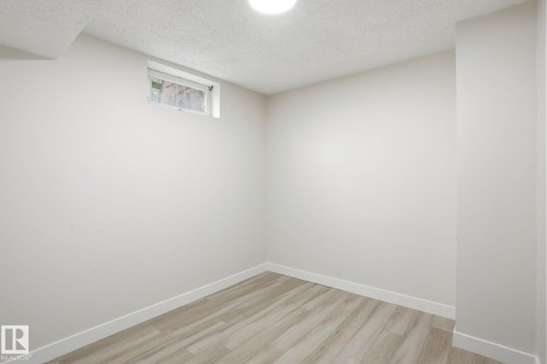 Compact room featuring light wood-finish flooring and a single window - 1008 61 Street, Edmonton, AB 