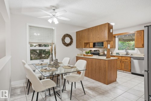 Dining area featuring tile flooring, a window with a roller shade, and a ceiling fan with integrated lighting - 1008 61 Street, Edmonton, AB 