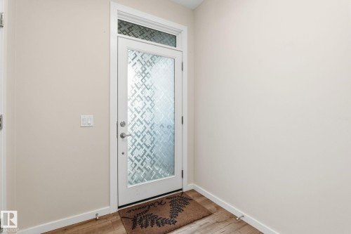 Entryway featuring a white door with frosted patterned glass and a transom window - 20011 26, Edmonton, AB 