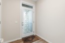Entryway featuring a white door with frosted patterned glass and a transom window - 20011 26, Edmonton, AB 
