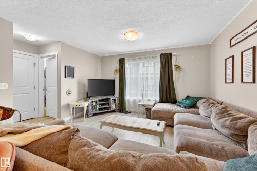 Spacious living area featuring light-toned walls and wood-finish flooring - 85 165 Cy Becker Boulevard, Edmonton, AB - Indoor Photo Showing Living Room